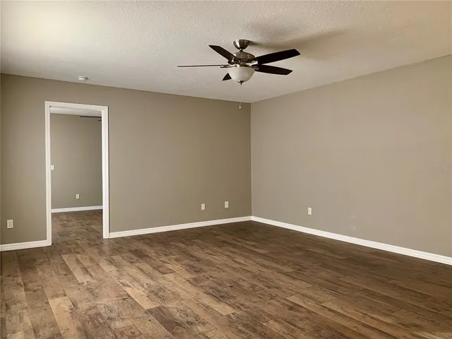 a view of room with hardwood floor and ceiling fan