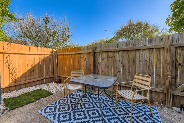a backyard of a house with table and chairs