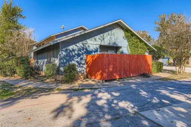 a view of a house with wooden fence