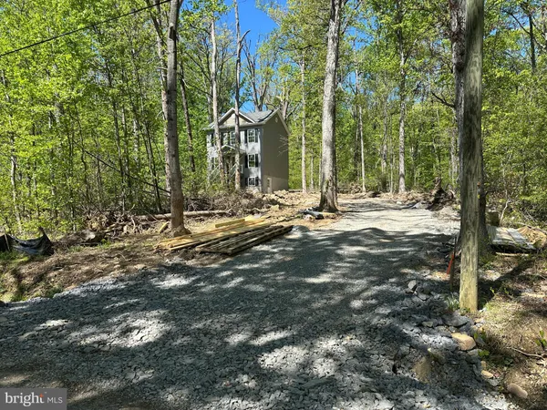 a view of a house with backyard and trees