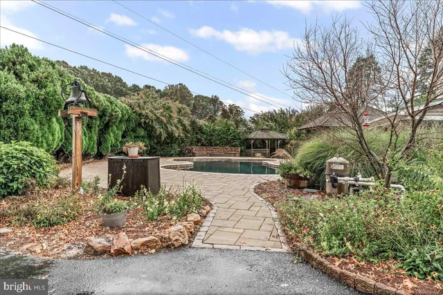 an aerial view of a residential houses with outdoor space and trees all around