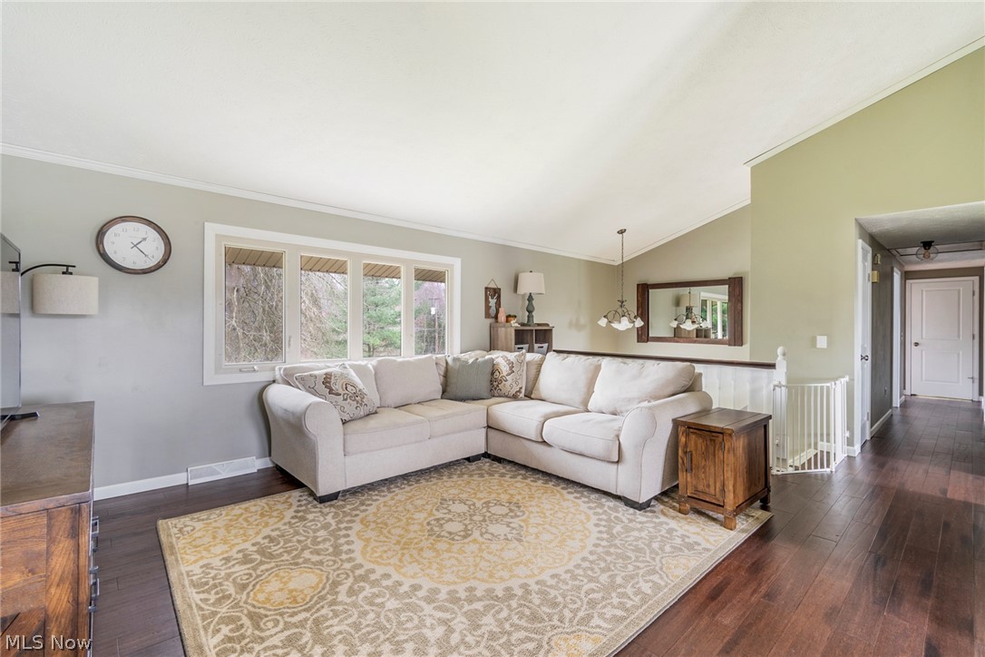 8370 Herbert Road Canfield, OH 44406 - Photo 39 of 48 Living room with dark hardwood / wood-style floors, an inviting chandelier, vaulted ceiling, and crown molding