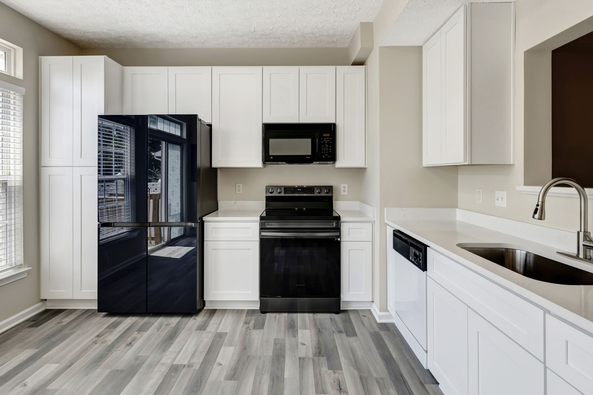 a kitchen with a refrigerator stove and microwave