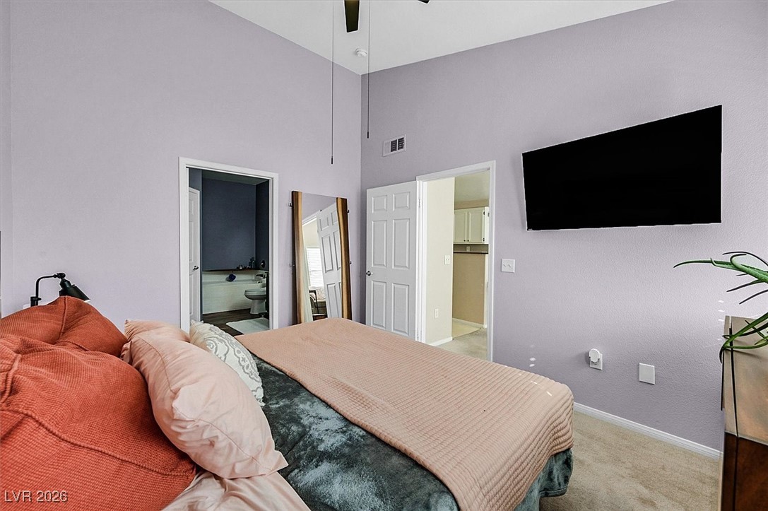 10550 West Alexander Road, Unit 2065 Las Vegas, NV 89129 - Photo 13 of 27 Carpeted bedroom with ensuite bathroom, a towering ceiling, and ceiling fan