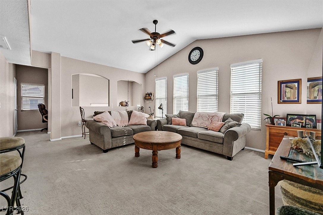 10550 West Alexander Road, Unit 2065 Las Vegas, NV 89129 - Photo 3 of 27 Carpeted living area featuring ceiling fan, lofted ceiling, and healthy amount of natural light
