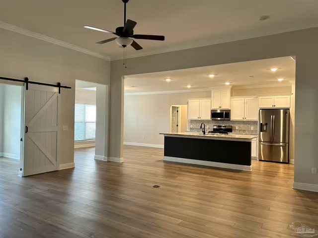 a view of kitchen with stainless steel appliances granite countertop refrigerator sink and stove