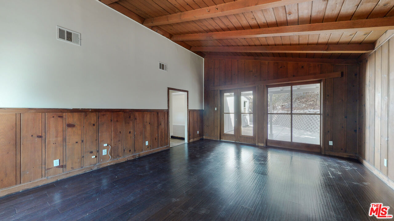 7865 Denivelle Road Sunland, CA 91040 - Photo 13 of 54 a view of an empty room with wooden floor and windows