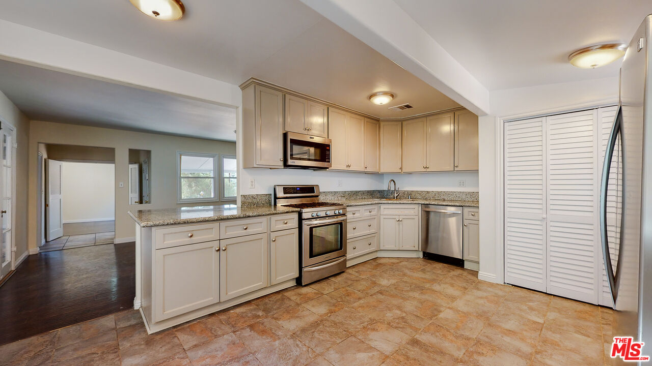 7865 Denivelle Road Sunland, CA 91040 - Photo 20 of 54 a kitchen with a sink stove and cabinets
