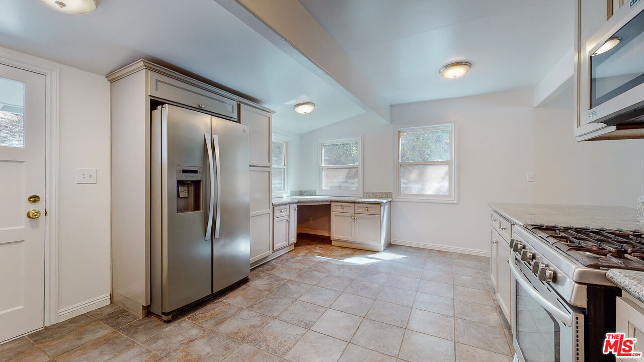 7865 Denivelle Road Sunland, CA 91040 - Photo 22 of 54 a kitchen with granite countertop a refrigerator and a stove