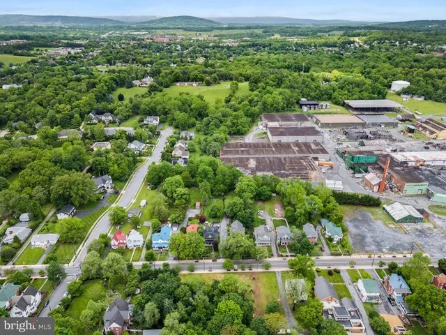 an aerial view of residential houses with outdoor space and street view