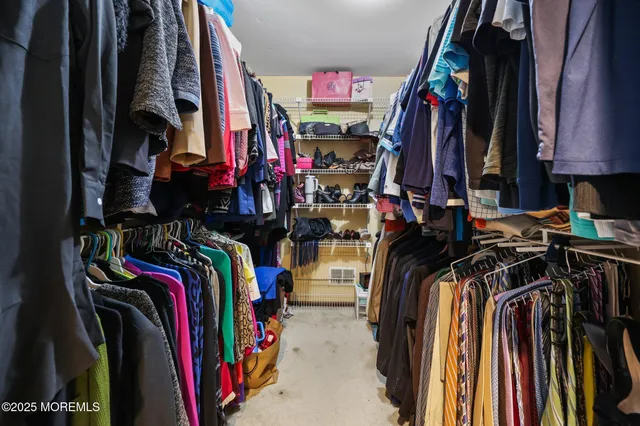 a view of walk in closet with clothes