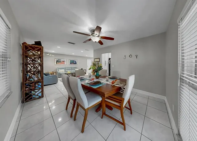 a living room with furniture a chandelier and a dining table