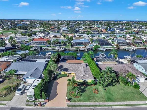 an aerial view of a city with lots of residential buildings ocean and mountain view in back