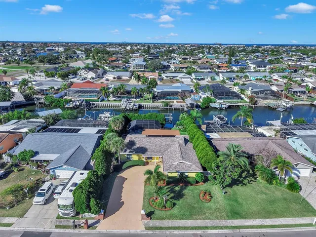 an aerial view of a city with lots of residential buildings ocean and mountain view in back