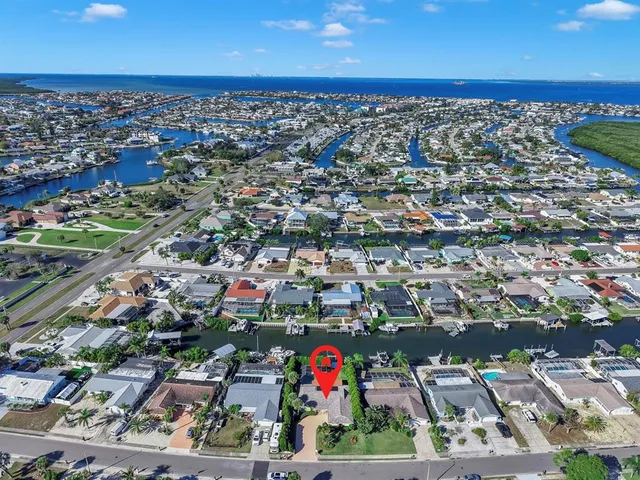 an aerial view of a house with a garden and lake view