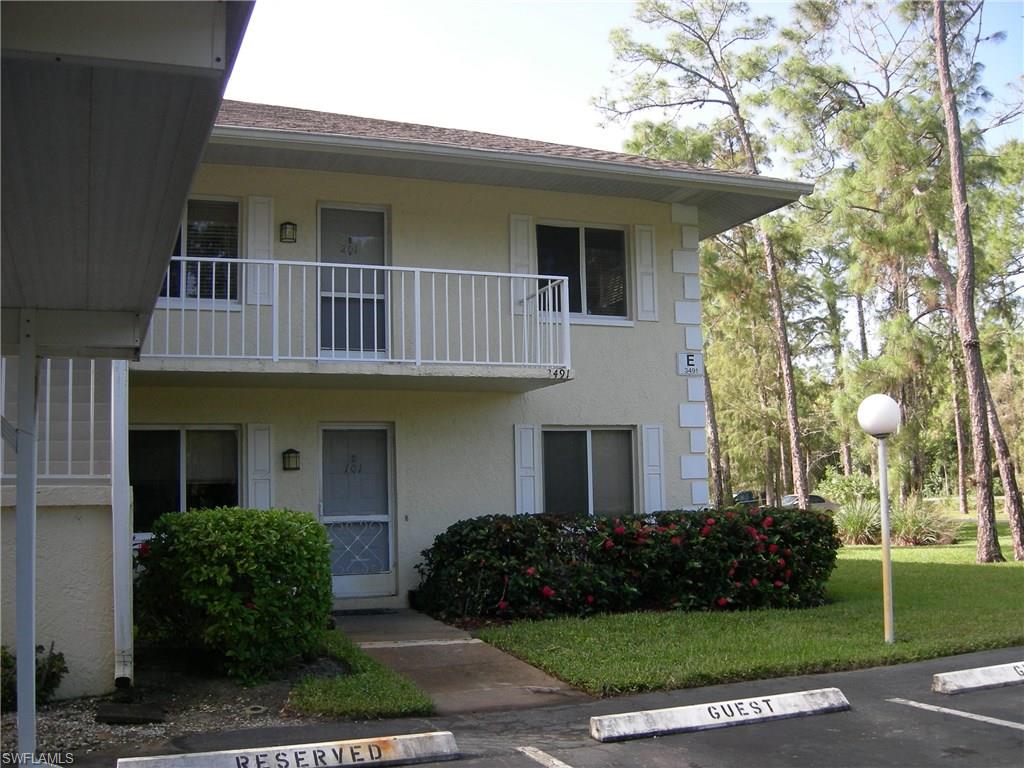 3491 County Barn Road, Unit E201 Naples, FL 34112 - Photo 12 of 15 a front view of a house with garden