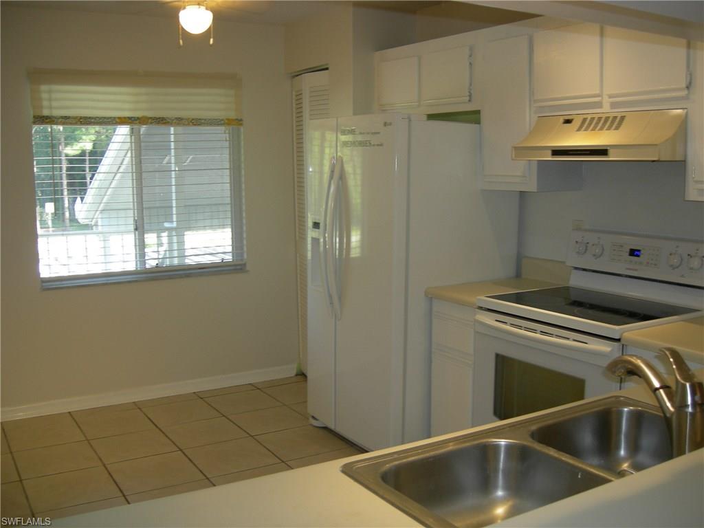 3491 County Barn Road, Unit E201 Naples, FL 34112 - Photo 3 of 15 a kitchen with a sink and cabinets