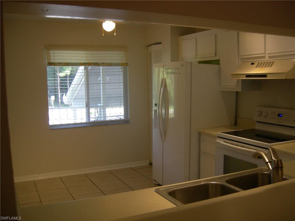 3491 County Barn Road, Unit E201 Naples, FL 34112 - Photo 4 of 15 a view of a kitchen with stainless steel appliances wooden floor and a window