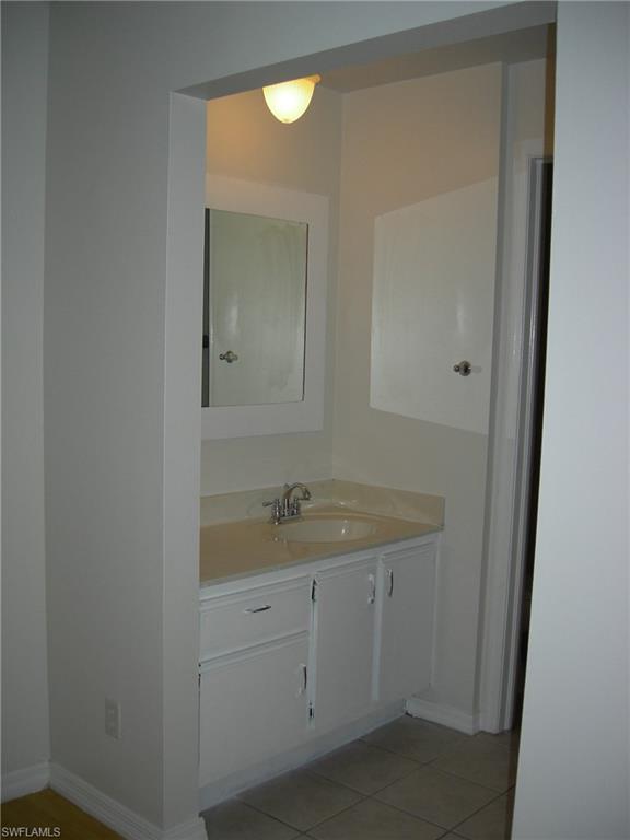 3491 County Barn Road, Unit E201 Naples, FL 34112 - Photo 6 of 15 a bathroom with a granite countertop sink and a mirror
