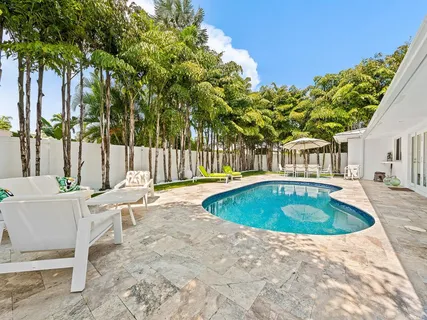 a view of a backyard with table and chairs with wooden fence