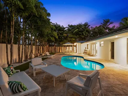 a view of a patio with table and chairs under an umbrella