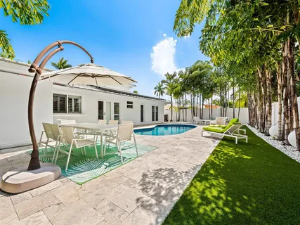 a view of a patio with couches table and chairs with wooden fence