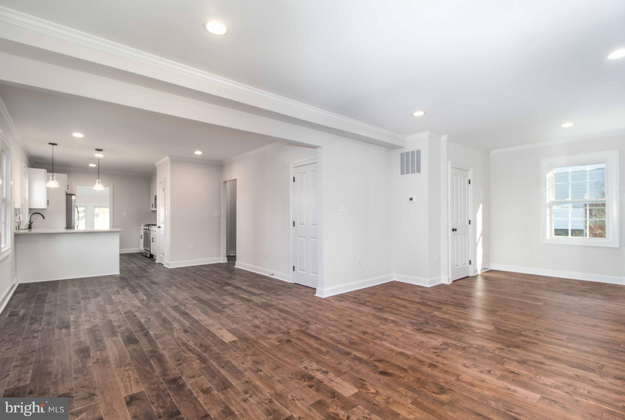 701 Brookwood Road Baltimore, MD 21229 - Photo 12 of 57 a view of an empty room with wooden floor and a window