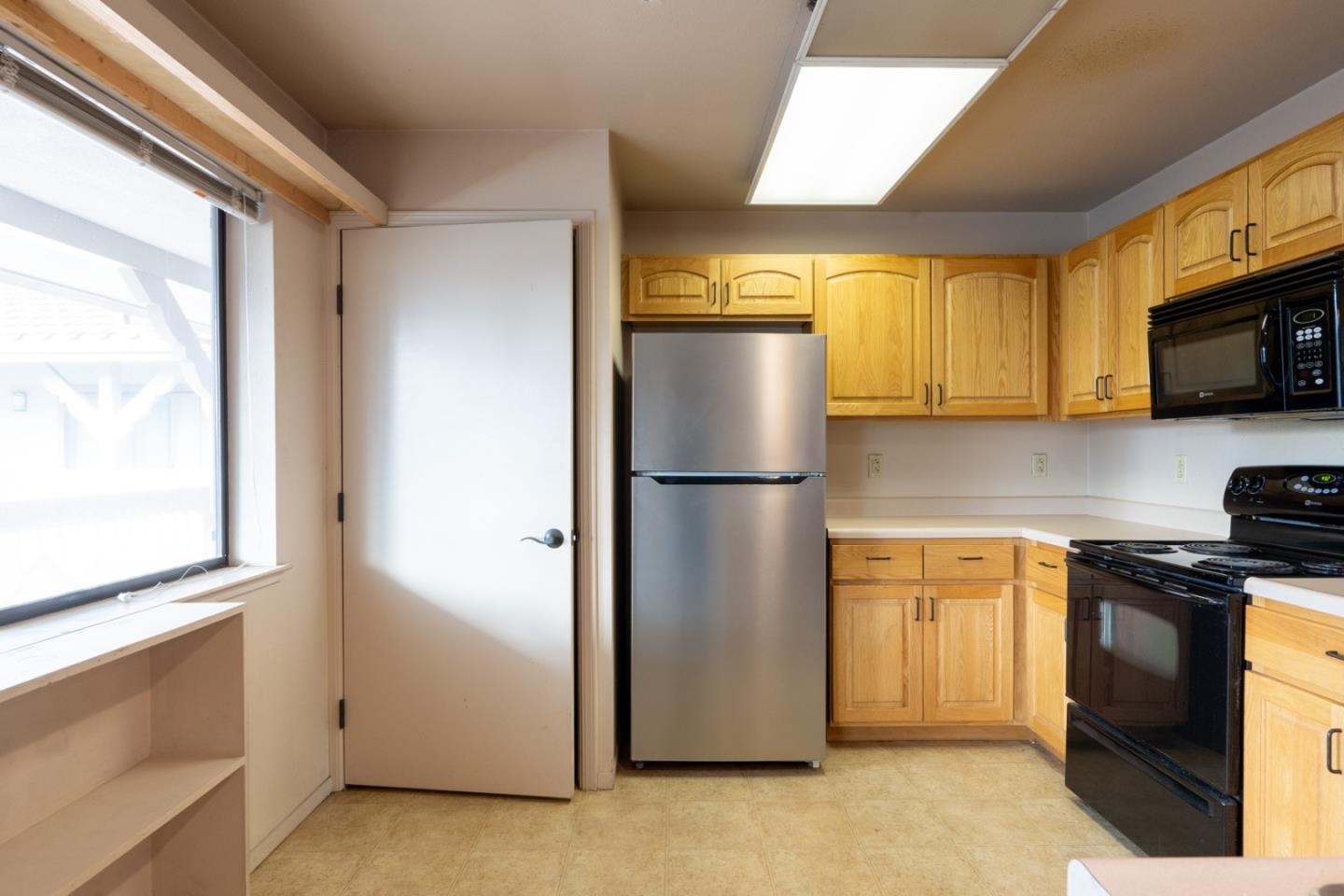 306 Reservation Road Marina, CA 93933 - Photo 9 of 23 a kitchen with stainless steel appliances granite countertop a refrigerator a microwave a sink and cabinets