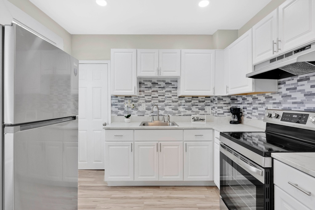 171 Boston Road Springfield, MA 01109 - Photo 11 of 33 a kitchen with white cabinets and stainless steel appliances