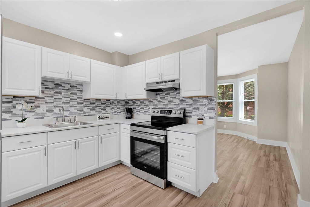 171 Boston Road Springfield, MA 01109 - Photo 9 of 33 a kitchen with cabinets stainless steel appliances a sink and wooden floor