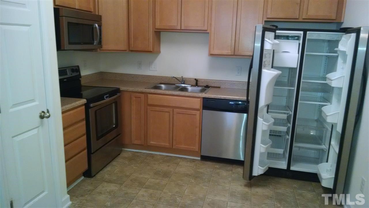 401 Coalinga Lane, Unit 102 Raleigh, NC 27610 - Photo 5 of 12 a kitchen with stainless steel appliances granite countertop a refrigerator a stove and a sink