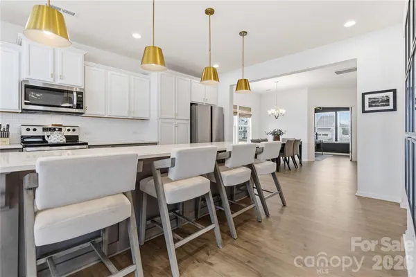 a kitchen with stainless steel appliances granite countertop a kitchen island a stove a table and chairs