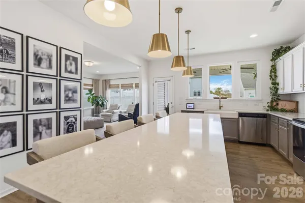 a large white kitchen with a large window and stainless steel appliances