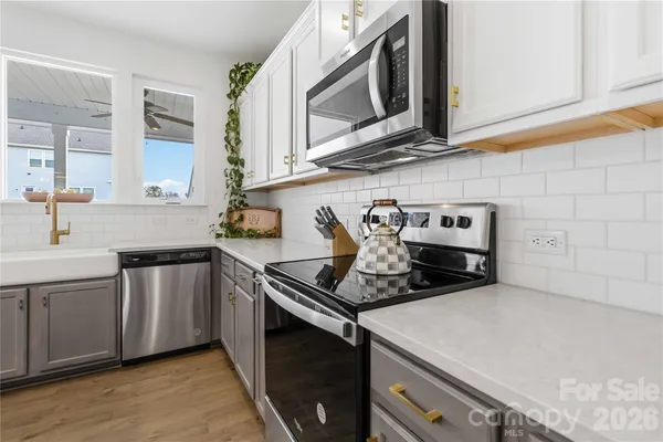 a kitchen with stainless steel appliances granite countertop a sink stove and cabinets