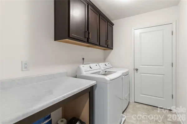 a utility room with cabinets washer and dryer