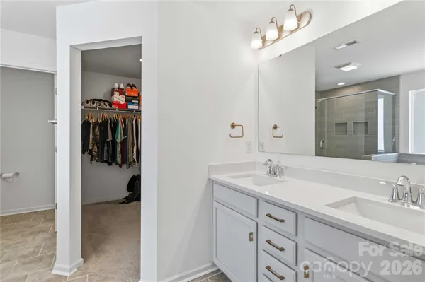 a en suite bathroom with a sink double vanity and mirror