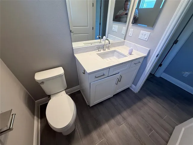 a bathroom with a toilet sink and mirror