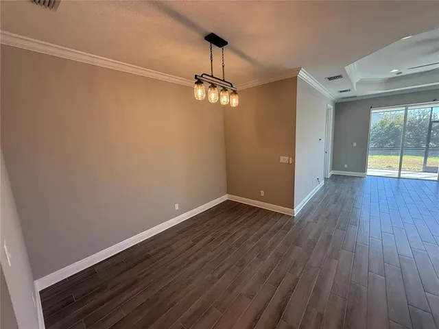 a view of a room with wooden floor and windows
