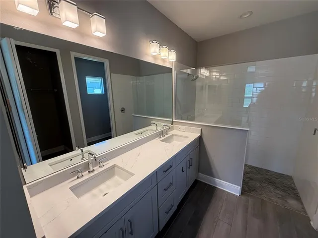 a bathroom with a double vanity sink and mirror