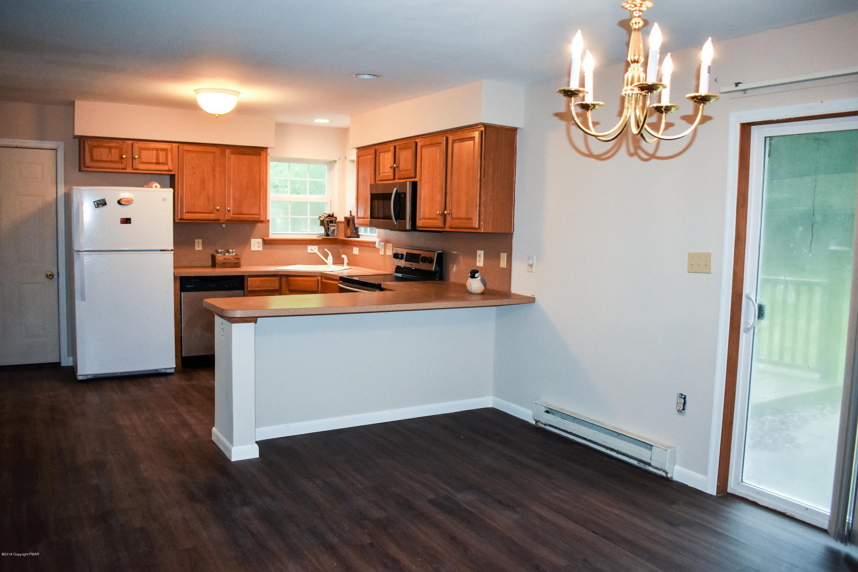 33 Sassafras Road Albrightsville, PA 18210 - Photo 11 of 36 a kitchen with wooden floor and white cabinets
