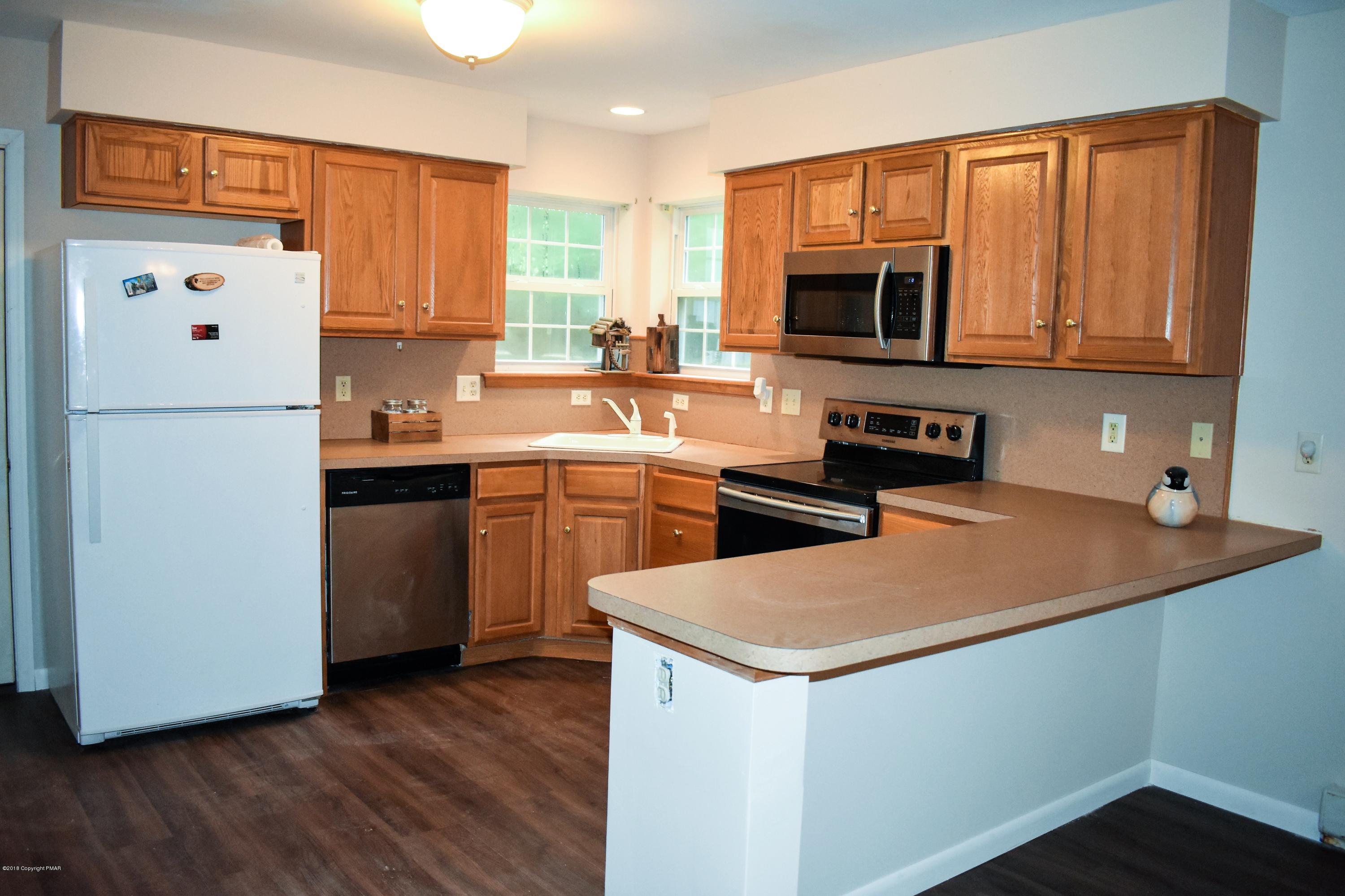 33 Sassafras Road Albrightsville, PA 18210 - Photo 12 of 36 a kitchen with stainless steel appliances a sink a stove a microwave a sink a refrigerator and cabinets