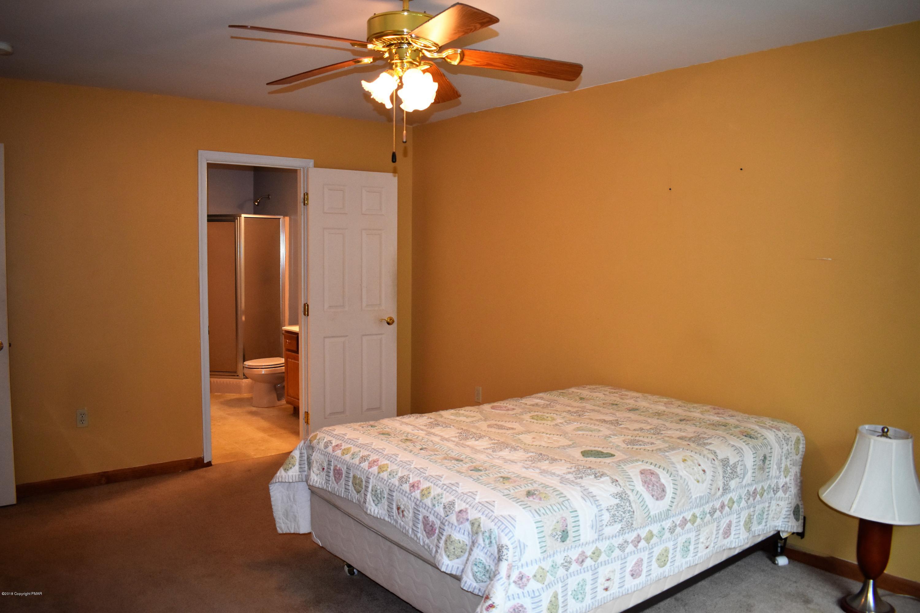 33 Sassafras Road Albrightsville, PA 18210 - Photo 20 of 36 a bedroom with a bed and a chandelier