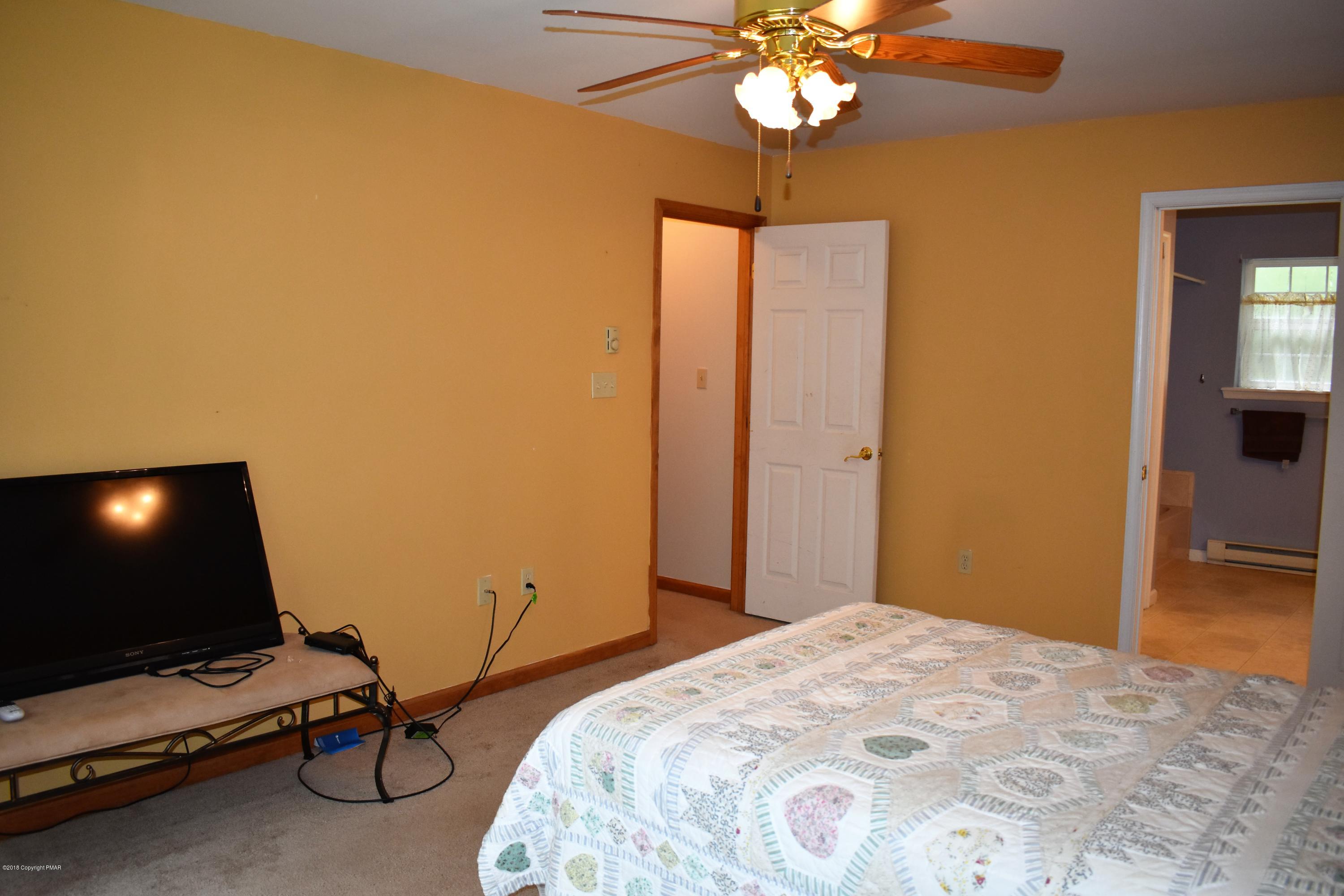 33 Sassafras Road Albrightsville, PA 18210 - Photo 21 of 36 a bedroom with a bed and a chandelier