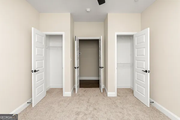 an empty room with a window and a ceiling fan