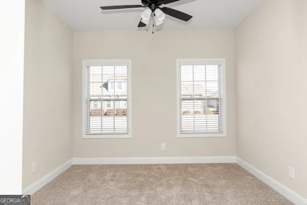 a view of a livingroom with a ceiling fan and window