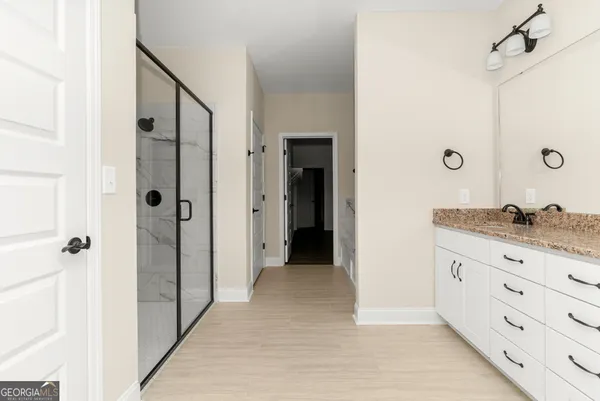a bathroom with a granite countertop sink mirror and cabinets
