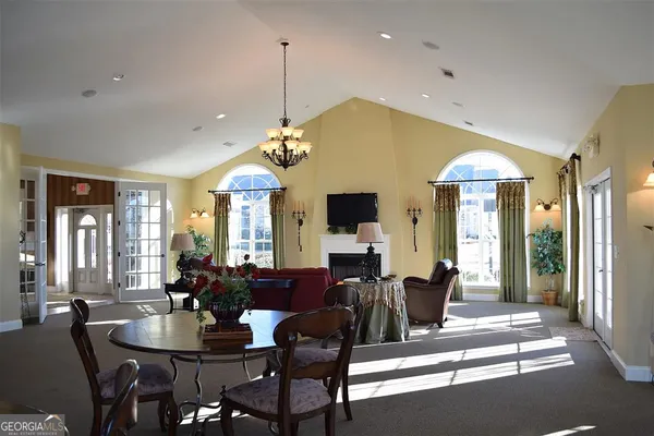 a living room with furniture a chandelier and a large mirror