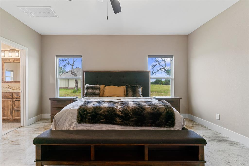 139 Kriston Lane Springtown, TX 76082 - Photo 21 of 39 Spacious room featuring two windows, a ceiling fan, and concrete flooring