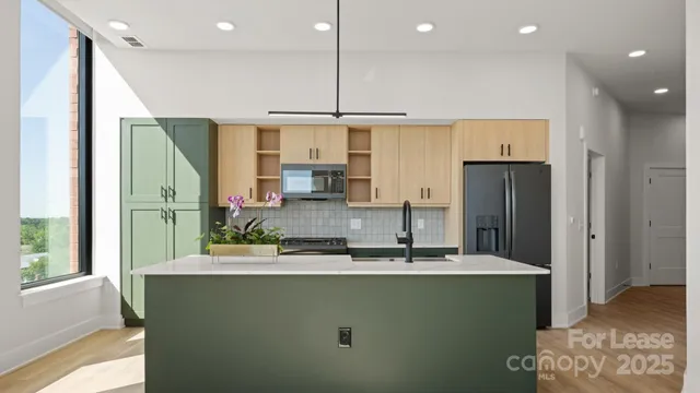 a kitchen with kitchen island granite countertop a sink a counter top space stainless steel appliances and cabinets