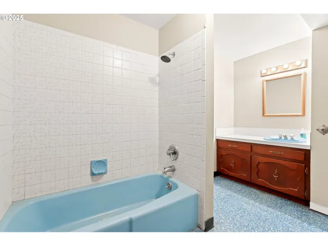 a bathroom with a tub a sink and mirror